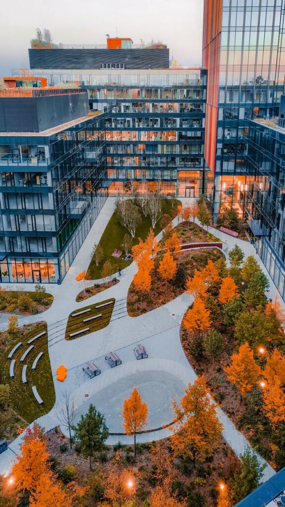 Stunning aerial view of a modern office complex in Warsaw with vibrant autumn foliage.